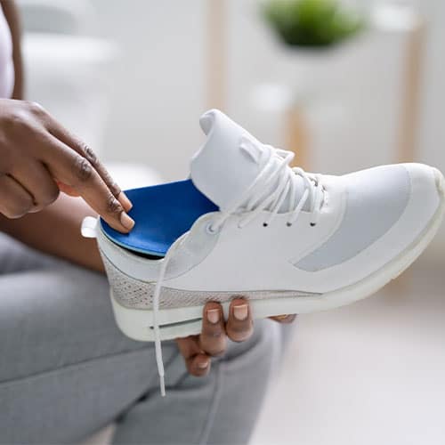 Comfortable white sneaker with orthopedic insole for foot support and pain relief.