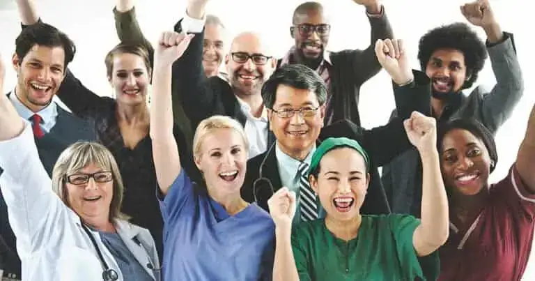 Diverse healthcare professionals celebrating teamwork and patient care success.