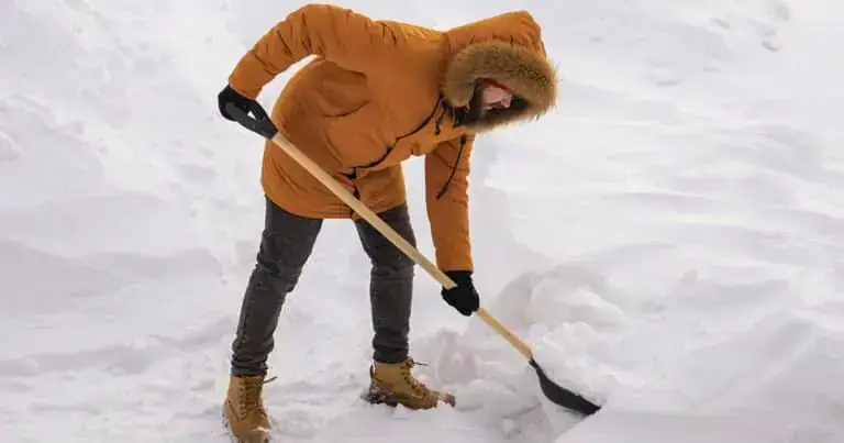 Person shoveling snow outdoors with proper technique for safe winter snow removal.