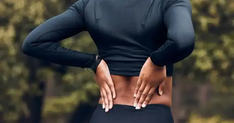 Person holding lower back, demonstrating pain relief methods for back pain management.