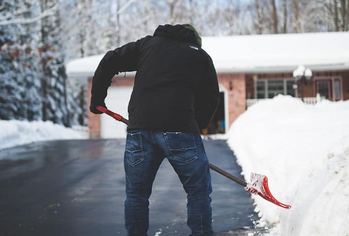 Snow shoveling in winter to clear driveway and pathways.