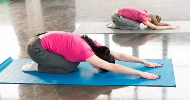 Woman performing no-equipment back stretch for pain relief.