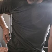 fit man at a chiropractor appointment getting help with lower back pain Back pain relief consultation with Dr. Rebecca-Jane McAllister, chiropractor specializing in pain management and spinal health.